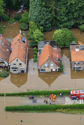 Foto van huizen die gedeeltelijk in het water staan door een overstroming